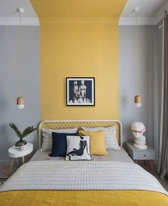 a bedroom with yellow walls and white bedding, artwork on the wall above the bed