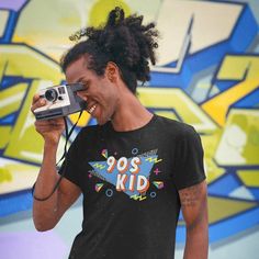 "Take me back to the best decade since the 80s! Everything was better in the 90s. Retro 90s Shirt | Retro Shirt | 90s Kid Shirt | Nostalgia Shirt | Best Of The 90s Shirt | 90s Kid Tee This t-shirt puts a new spin on casual comfort. Made from very soft materials, this tee is 100% cotton for solid colors. Heather colors and sports grey include polyester. The shoulders have twill tape for improved durability. There are no side seams. The collar is made with ribbed knitting to prevent curling damage.   * Unisex Basic Softstyle T-Shirt - Gildan 64000* * 100% cotton (fiber content may vary for different colors) * 4.5 oz/yd² (153 g/m²) * Pre-shrunk * Shoulder-to-shoulder taping * Eurofit * Tear-away label * Runs true to size * Quarter-turned to avoid crease down the center + Please check size cha 90s Inspired Short Sleeve Screen Print T-shirt, 90s Inspired Short Sleeve T-shirt For Fans, 90s Inspired Letter Print T-shirt For Streetwear, 90s Inspired Crew Neck T-shirt With Funny Print, 90s Inspired Short Sleeve Graphic T-shirt, 90s Inspired Short Sleeve T-shirt With Graphic Design, 90s Graphic Design T-shirt For Summer, 90s Style Graphic T-shirt For Summer, 90s Inspired Fan Merchandise T-shirt For Summer