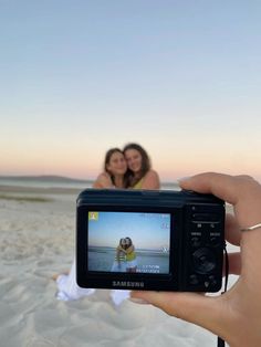 two women taking a photo on the beach