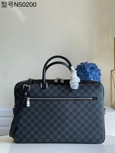 a louis vuitton bag sitting on top of a table next to a vase