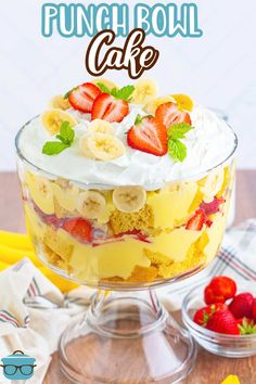 a cake with bananas, strawberries and whipped cream on top that says punch bowl cake