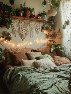 a bed with lots of plants and lights on the wall above it, in front of a window