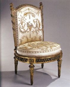 an ornately decorated chair with gold trimmings and white upholstered seat