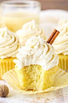 two cupcakes with white frosting and cinnamon sticks