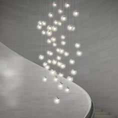 a large chandelier hanging from the ceiling in a room with white walls and stairs