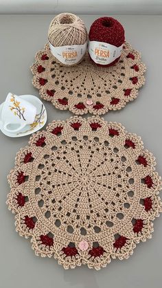 two crocheted doily with balls of yarn