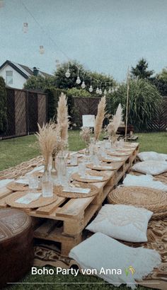 an outdoor table set up with white pillows and placemats for dinner guests to eat