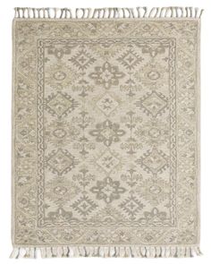 a beige rug with fringes on the bottom and an intricate design in the middle