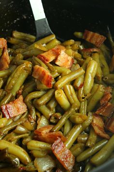 green beans and bacon are being cooked in a skillet