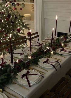 the table is set for christmas dinner with candles