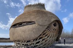 an unusual looking building sitting on top of a sandy beach