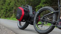 a bicycle parked on the side of a road next to a person wearing black shoes