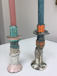 there are two candles that have been placed on top of each other in different colors