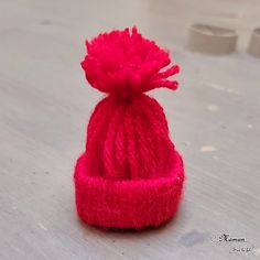 a red knitted hat sitting on top of a wooden table