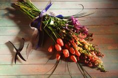 a bunch of flowers laying on top of a wooden floor