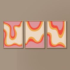 three abstract paintings hang on the wall