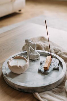 a tray with two candles and an angel figurine on it