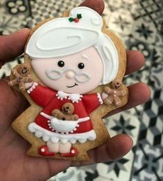 a hand holding a cookie shaped like an old lady