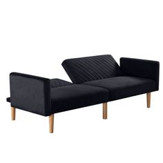 a black couch sitting on top of a white floor next to a wooden leg chair