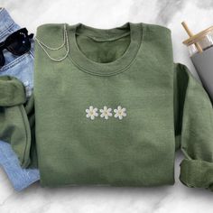 "Elevate your style with our \"Daisy Flower Embroidered Sweatshirt.\" This charming sweatshirt is a celebration of daisy flowers, featuring beautifully embroidered blossoms that add a touch of natural elegance to your wardrobe. 🌼 Daisy Delight: Our sweatshirt showcases intricately embroidered daisy flowers, allowing you to embrace the beauty of nature wherever you go. It's the perfect blend of fashion and comfort for daisy lovers. 💐 Versatile Chic: Whether you're off for a casual day out, enjoying a cozy evening at home, or simply want to add a touch of floral elegance to your attire, this sweatshirt effortlessly enhances your style. 🍃 Unmatched Comfort: Crafted from soft and high-quality materials, our crewneck sweatshirt offers cozy warmth and comfort. It's the perfect choice for stay Crochet Shoes Pattern, Crochet Bandana, Floral Sweatshirt, Daisy Flowers, Crochet Shoes, Sweater Gift, Embroidered Clothes, Embroidered Sweatshirt, Stylish Gifts