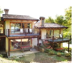 the house is surrounded by trees and has two levels that are connected to each other