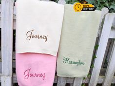 three personalized towels hanging on a fence