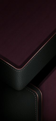 a close up view of a cell phone on top of a leather case with stitching