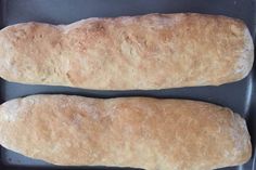 two loaves of bread sitting on top of a pan