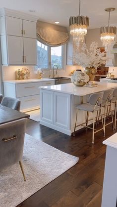 a kitchen filled with lots of white furniture