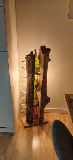 a wine rack made out of tree branches and bottles in the middle of a room