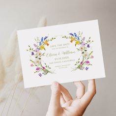 a person holding up a card with flowers on it and the words save the date