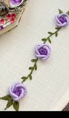 some purple flowers are on a white cloth