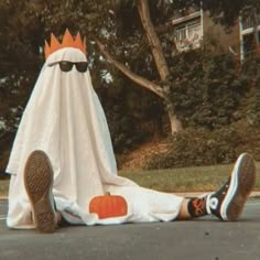 a person laying on the ground next to a fake ghost