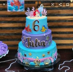 there is a cake that has the number six on it and mermaid decorations around it