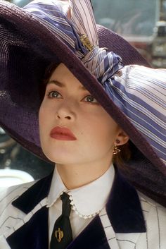 a woman wearing a large purple hat and tie