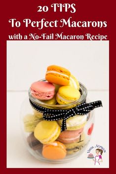 a jar filled with macaroons sitting on top of a white table next to cookies