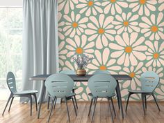 a dining room table with four chairs in front of a wallpapered flower pattern