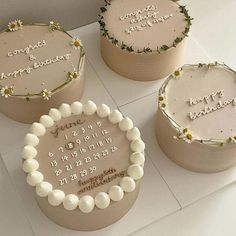 three decorated cakes sitting on top of a white counter next to each other with writing on them