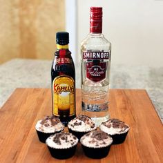 some cupcakes and a bottle of alcohol on a table