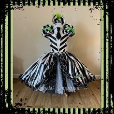 a dress made out of black and white striped fabric with green accents on the bust