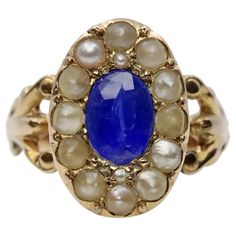 A handmade original victorian period Kyanite, and natural pearl ring in 14 karat yellow gold. Centered by a 1.20 carat rich velvety blue oval cut Kyanite and encircled by fourteen natural half pearls. In excellent condition, this ring is a size 6 US and is sizable. This ring measures 14mm across the top from north to south and tests as 14 karat gold. Natural Pearl Ring, Kyanite Ring, Victorian Period, Baguette Diamond Rings, Natural Pearl, Filigree Ring, Pearl Earrings Dangle, Art Deco Diamond, Multi Stone Ring