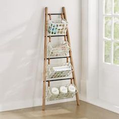 a wooden ladder with baskets on it next to a window