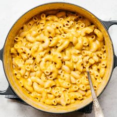 a pot filled with macaroni and cheese on top of a white countertop