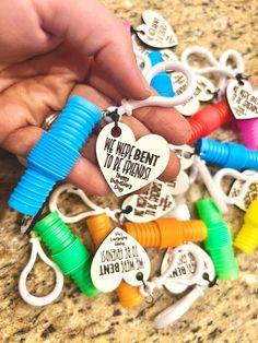 a person is holding several different colored bracelets