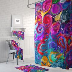 a colorful shower curtain and rug in a bathroom