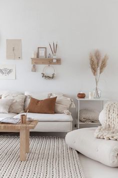 a living room filled with furniture and decor on top of a white floor covered in grey rugs