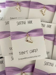 several different types of hair clips are tied together with purple ribbons and tags that read, skating hair don't care