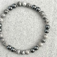 Men's beaded bracelet features: ~ 6mm, 8mm or 10mm Map Jasper beads ~ 6mm, 8mm or 10mm Hematite beads ~ 4mm, 6mm or 8mm stainless steel spacers ~ Strong, non-fraying elastic cord; simply slide bracelet on and off wrist ~ Comes packaged in a re-usable micro fibre pouch To ensure the perfect fit, please use the bracelet sizing instructions found in the photo gallery. Casual Round Beaded Hematite Bracelets, Gray Hand-strung Bracelets With Round Beads, Slide Bracelet, Hematite Bracelet, Hematite Beads, Mens Beaded Bracelets, Jasper Beads, Minimalist Fashion, Bracelets For Men