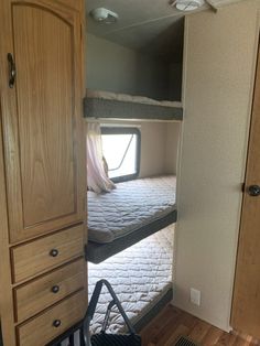 two bunk beds in a small room with wood flooring and closets on either side