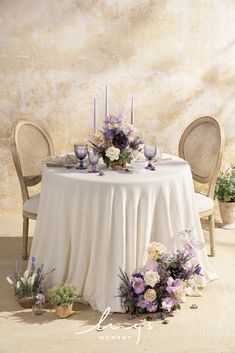 the table is set with flowers and candles